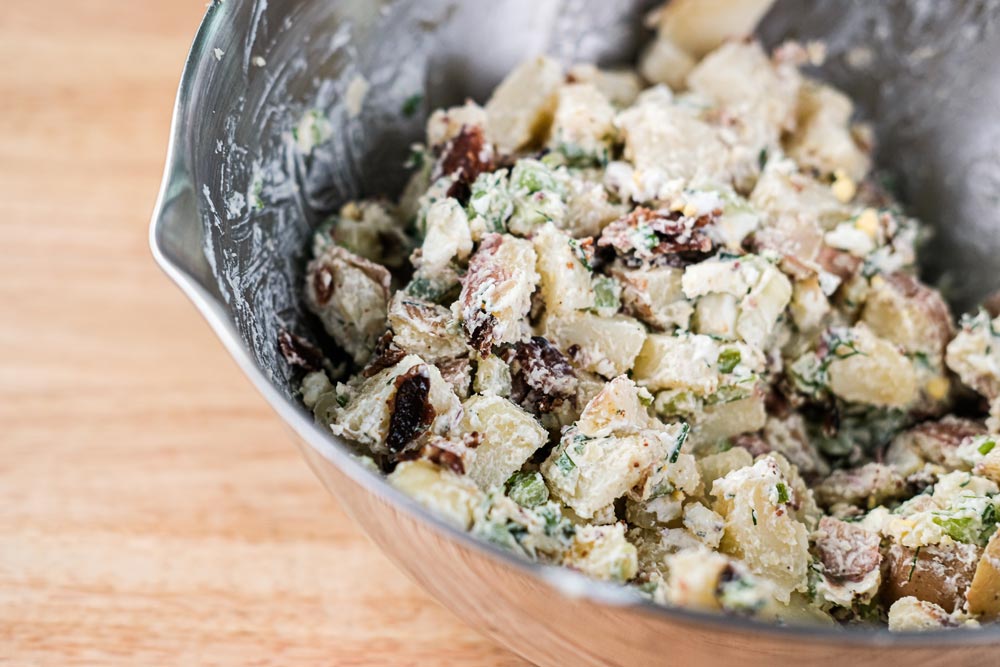 Silver metal mixing bowl with potato salad.